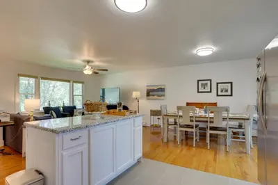 a kitchen and living room with a table and chairs at Kiamesha Lake Home with Deck 4 Mi to Resorts World! in Monticello