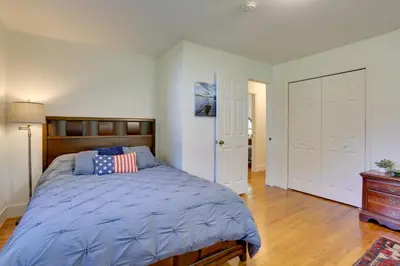 a bedroom with a bed with a blue comforter at Kiamesha Lake Home with Deck 4 Mi to Resorts World! in Monticello