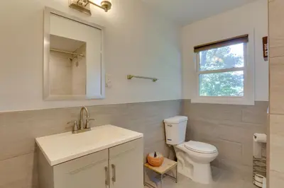 a bathroom with a toilet and a sink and a window at Kiamesha Lake Home with Deck 4 Mi to Resorts World! in Monticello