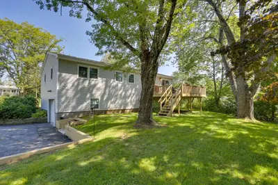 a house with a tree in the yard at Kiamesha Lake Home with Deck 4 Mi to Resorts World! in Monticello
