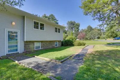 a white house with a driveway in the yard at Kiamesha Lake Home with Deck 4 Mi to Resorts World! in Monticello