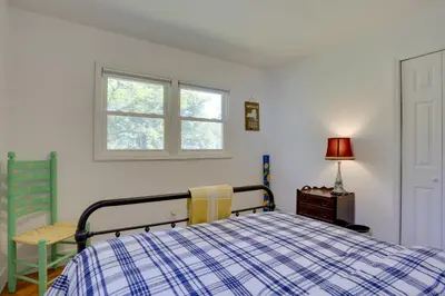 a bedroom with a bed and a table and a window at Kiamesha Lake Home with Deck 4 Mi to Resorts World! in Monticello