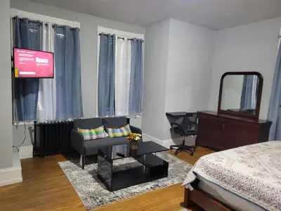 a bedroom with a bed and a chair and a mirror at A Victorian home in Philadelphia