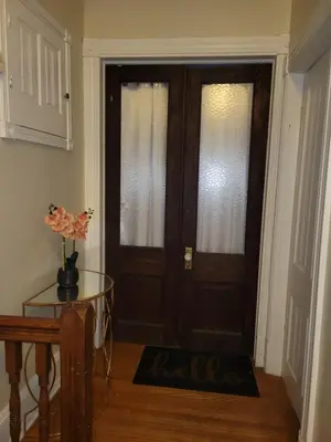 a door in a room with a table and a glass door at A Victorian home in Philadelphia