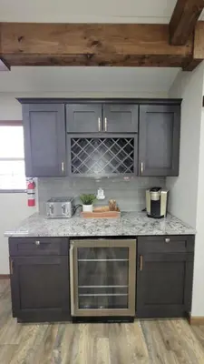 a kitchen with black cabinets and granite counter tops at Whiskey Pines Retreat! Single Level Home, Outdoor Firepit, AC, BBQ! Sleeps 9 in Lake Harmony! in Lake Harmony