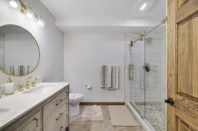 a bathroom with a shower and a toilet and a mirror at Whiskey Pines Retreat! Single Level Home, Outdoor Firepit, AC, BBQ! Sleeps 9 in Lake Harmony! in Lake Harmony