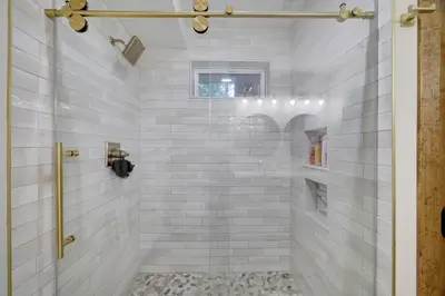a bathroom with a shower with white tiles at Whiskey Pines Retreat! Single Level Home, Outdoor Firepit, AC, BBQ! Sleeps 9 in Lake Harmony! in Lake Harmony