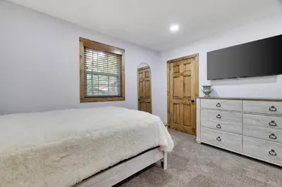 a bedroom with a bed and a flat screen tv at Whiskey Pines Retreat! Single Level Home, Outdoor Firepit, AC, BBQ! Sleeps 9 in Lake Harmony! in Lake Harmony