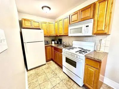a kitchen with white appliances and wooden cabinets at Lennox C402 Peaceful & Perfect Private 1-Br in Philadelphia