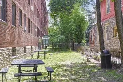 a group of picnic tables next to a brick building at Lennox C101 Perfect & Peaceful Studio Apt in Philadelphia