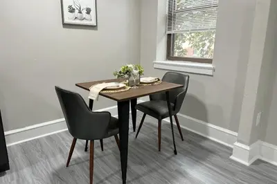 a dining room table with two chairs and a table with flowers on it at Lennox C101 Perfect & Peaceful Studio Apt in Philadelphia