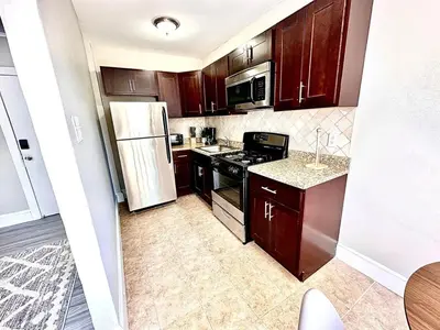 a kitchen with wooden cabinets and a white refrigerator at Lennox C301 Peaceful & Perfect Studio Apt in Philadelphia