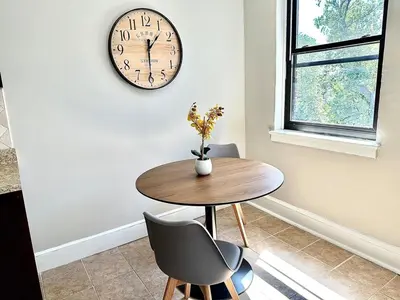 a dining room with a table and a clock on the wall at Lennox C301 Peaceful & Perfect Studio Apt in Philadelphia