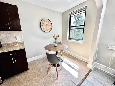 a kitchen with a table and a clock on the wall at Lennox C301 Peaceful & Perfect Studio Apt in Philadelphia