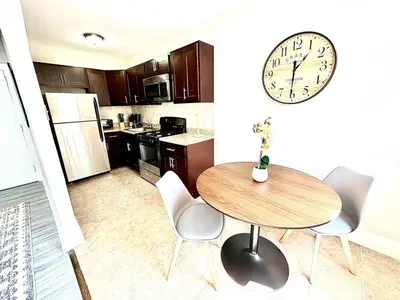 a kitchen with a table and a clock on the wall at Lennox C405 Peaceful & Perfect Studio Apt in Philadelphia