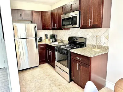 a kitchen with wooden cabinets and stainless steel appliances at Lennox C405 Peaceful & Perfect Studio Apt in Philadelphia