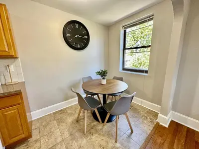 a dining room with a table and a clock on the wall at Lennox C303 Peaceful, Perfect Private Studio1br in Philadelphia