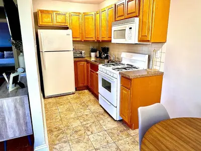 a kitchen with a white refrigerator and wooden cabinets at Lennox C304 Peaceful & Perfect Private 1-br in Philadelphia