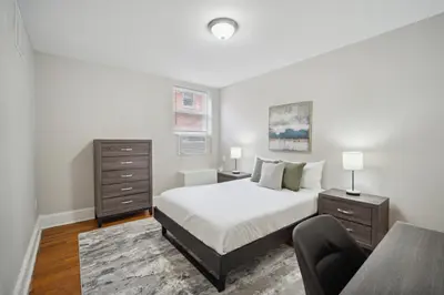 a white bedroom with a bed and a chair at Lennox C302 Peaceful & Perfect Private 1Br in Philadelphia