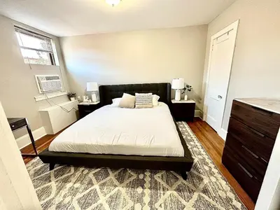a bedroom with a bed and two tables and a window at Lennox C409 Peaceful & Perfect Private 1-Br in Philadelphia