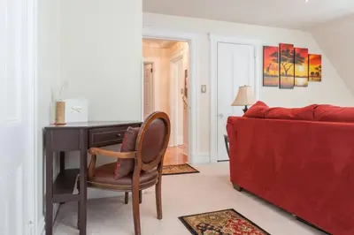 a living room with a red couch and a desk at Large Space Great for Groups & Families in Montclair