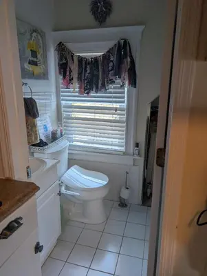 a white bathroom with a toilet and a window at Large Space Great for Groups & Families in Montclair