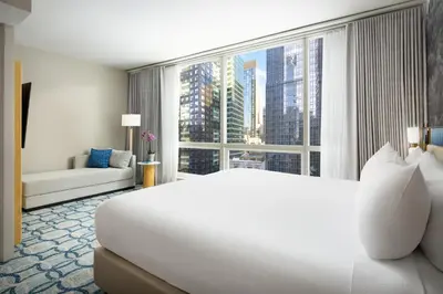 a bedroom with a large white bed and a large window at Millennium Premier Hotel New York Times Square in New York