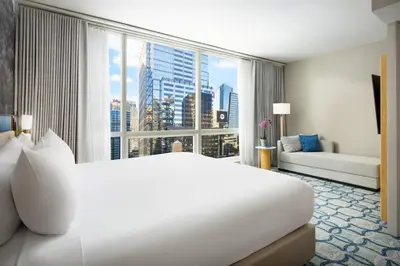 a bedroom with a large white bed and a large window at Millennium Premier Hotel New York Times Square in New York