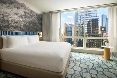 a bedroom with a large white bed and a large window at Millennium Premier Hotel New York Times Square in New York