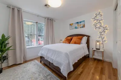a bedroom with a bed and a large window at 3br private Apartment in Jersey City