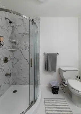 a white bathroom with a shower and a toilet at 3br private Apartment in Jersey City