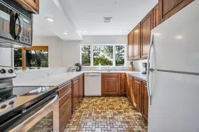 a kitchen with wooden cabinets and a white refrigerator at Lakefront Home at Lake Winola, PA in Factoryville