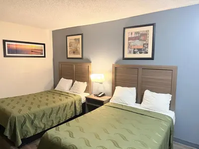 a hotel room with two beds and a lamp at Express Inn-Rahway in Rahway