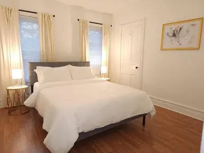 a white bed in a bedroom with two windows at Bethlehem Bliss:10min to Valley Festivals & Events in Bethlehem