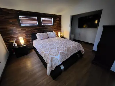 a bedroom with a large bed and a flat screen tv at little cozy house in a village in Mountain Dale
