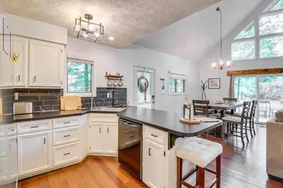 a kitchen with white cabinets and a dining room at Deck, Fire Pit and Pool Access Pennsylvania Home! in Albrightsville