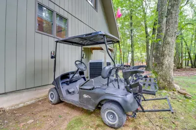 a golf cart parked in front of a house at Deck, Fire Pit and Pool Access Pennsylvania Home! in Albrightsville