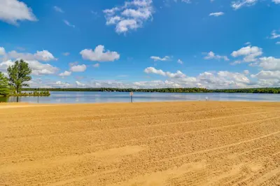 a sandy beach next to a body of water at Deck, Fire Pit and Pool Access Pennsylvania Home! in Albrightsville