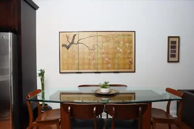 a dining room table with chairs and a painting on the wall at Peaceful Zen Getaway in the City in Philadelphia