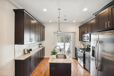 a kitchen with black cabinets and a stainless steel refrigerator at Peaceful Zen Getaway in the City in Philadelphia