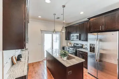 a kitchen with wooden cabinets and a stainless steel refrigerator at Peaceful Zen Getaway in the City in Philadelphia