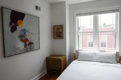 a white bedroom with a bed and a window at Peaceful Zen Getaway in the City in Philadelphia
