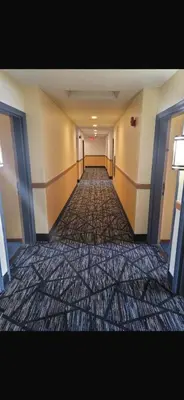 an empty hallway of a hotel with a carpeted floor at Americas Best Value Inn Horseheads in Elmira