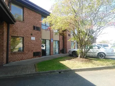 a car parked next to a brick building with a tree at Americas Best Value Inn Horseheads in Elmira