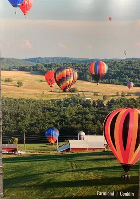 a group of hot air balloons flying over a field at Americas Best Value Inn Horseheads in Elmira