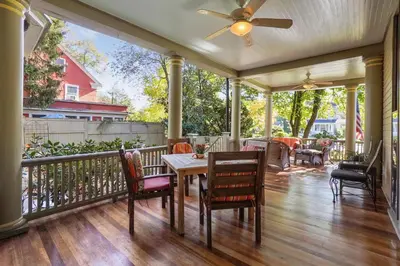 a porch with a table and chairs and a ceiling fan at DeBary Inn in Summit