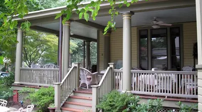 a house with a porch with rocking chairs on it at DeBary Inn in Summit