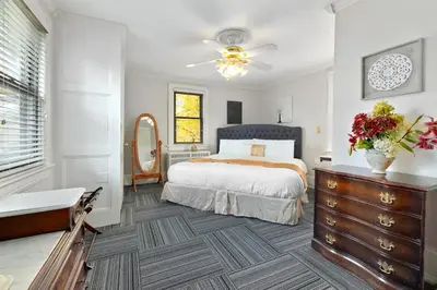 a bedroom with a bed and a dresser and a mirror at DeBary Inn in Summit