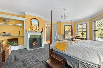 a bedroom with a bed and a fireplace at DeBary Inn in Summit