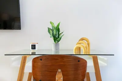 a glass table with a wooden chair and a plant at 74-1C New Studio With private outdoors - GYM in New York